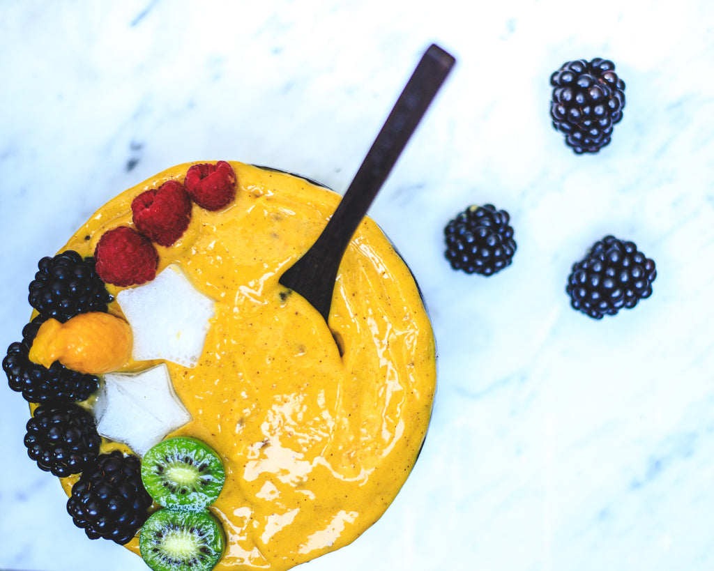 Tumeric And Mango Smoothie Bowl In A Coconut Bowl